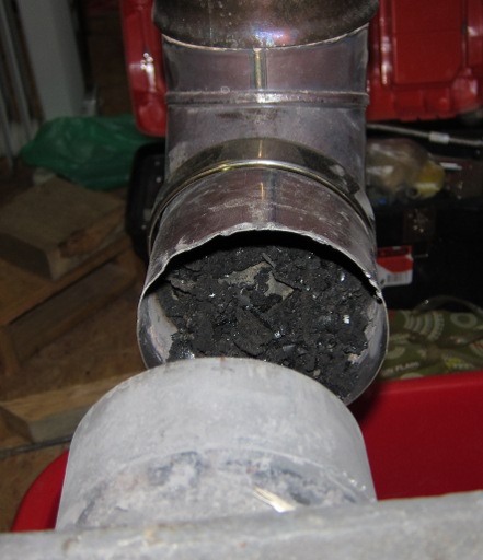 Неправильно смонтированный дымоход: колено полностью забито сажей